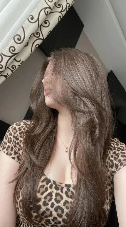 Woman with porcelain skin in leopard top looks directly at camera