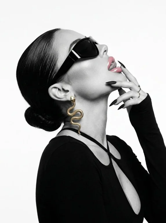 A model in black glasses tilts her head back with glossy lips.