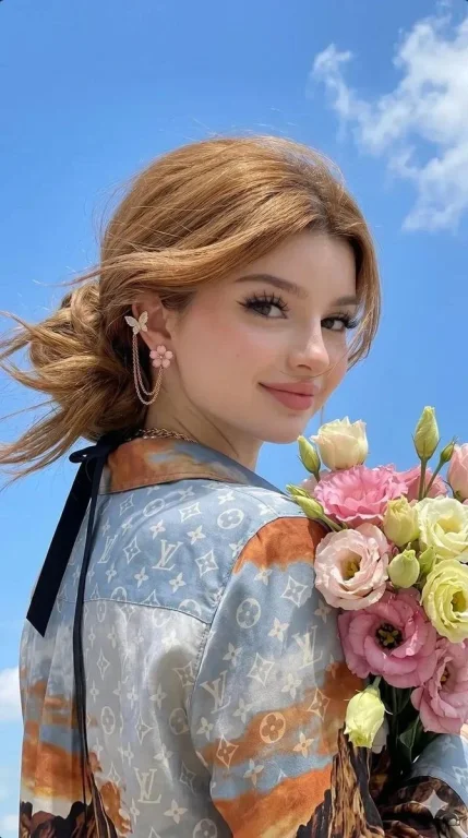 Young woman in golden hour light wears butterfly earrings
