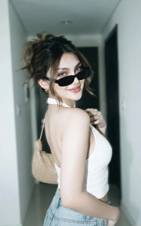 Young woman in motion blur poses with white halter top