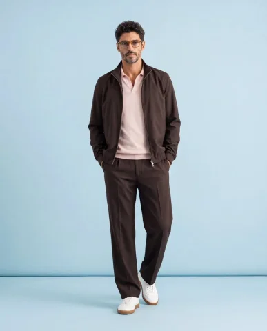 Model in neutral tailoring poses calmly against seamless backdrop — Nano Banana 2 AI Prompt: A high-end luxury fashion editorial photoshoot of a stylish model standing in a...