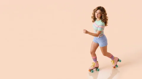 A 1970s woman in pastel roller skates poses for studio lighting — Nano Banana 2 AI Prompt: From a high angle, capture a hyper-realistic 8k image of a woman in her 20's fro...