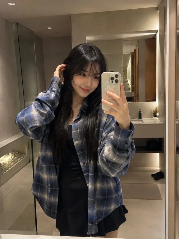 Japanese woman takes a casual mirror selfie in a blue flannel shirt