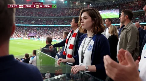 A focused hijabi fan watches a tense World Cup penalty kick — Nano Banana 2 AI Prompt: Create a photorealistic candid live football television broadcast shot using the...