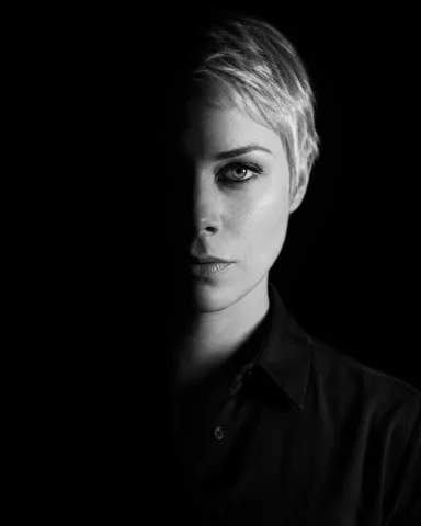 A dramatic monochrome portrait with split lighting and deep shadows — Nano Banana 2 AI Prompt: A dramatic, high-contrast low-key portrait of a subject. The image must be in mo...