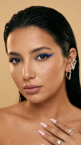 Woman with cobalt graphic liner stares intensely into the lens — Nano Banana 2 AI Prompt: { "medium": "analog editorial beauty photograph", "camera": "85mm lens,...