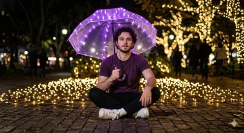 Young man sits under glowing purple umbrella on brick pavement at night — Nano Banana 2 AI Prompt: Ultra-realistic DSLR portrait of a young man sitting cross-legged on a brick pav...