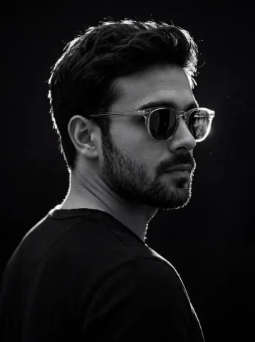Cinematic Contemplation in Shadows — Nano Banana 2 AI Prompt: - A dramatic high-contrast studio portrait of a young man with dark messy hair...