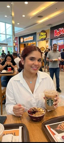 Casual Coffee Moment in a Busy Mall — Nano Banana 2 AI Prompt: casual iPhone photo of a person sitting in a Brazilian mall food court holding a...
