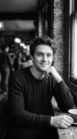 Textured Portrait in Rustic Café Light — Nano Banana 2 AI Prompt: A high-quality black and white portrait of a young man with tousled, textured ha...