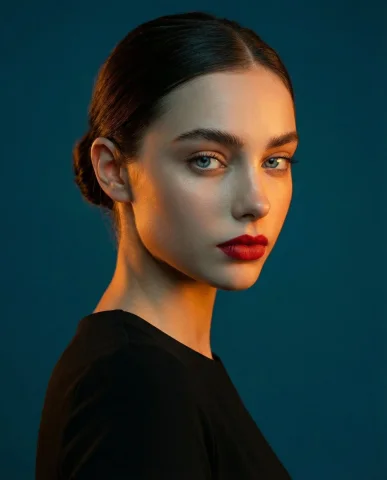 Golden Glow Portrait with Teal Contrast — Nano Banana 2 AI Prompt: A studio portrait, medium shot of a woman. High-contrast lighting: warm orange-g...