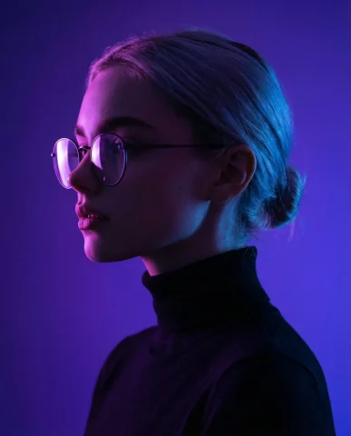 Cinematic Portrait of a Young Man in Neon Glow — Nano Banana 2 AI Prompt: Create a minimalist cinematic side-profile portrait of a young man with round gl...