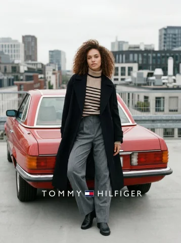 Sophisticated Urban Fashion: Classic Meets Contemporary — Nano Banana 2 AI Prompt: Eye-Level medium shot of a female model with Curly hair, standing still and lean...