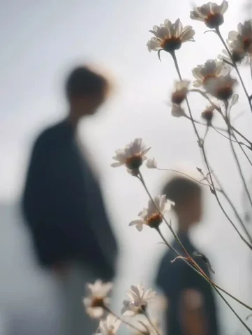 Blurred Flowers Minimalist Shot — Midjourney v6 AI Prompt: Flowers approach the camera, blurred and out of focus, with the backs of mother...