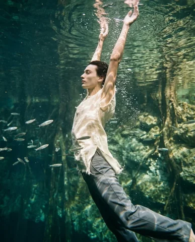 Underwater Surreal Fashion Editorial 7 — Nano Banana AI Prompt: Wide shot of a vast emerald cenote with a model floating small in the center of...