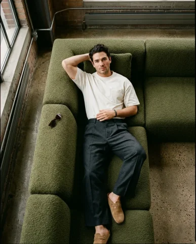 Industrial Loft Menswear Lounge 4 — Nano Banana AI Prompt: Editorial fashion photograph in a converted warehouse loft. A male model walking...