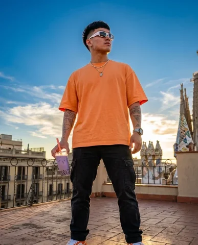 Barcelona Rooftop Boba Streetwear Portrait 7 — Nano Banana AI Prompt: Low-angle hero shot of a young man against a deep blue Barcelona sky, golden rim...