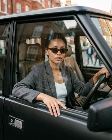 Street Style SUV Fashion 6 — Nano Banana AI Prompt: Street style fashion photograph of a stylish woman opening the driver's door of...