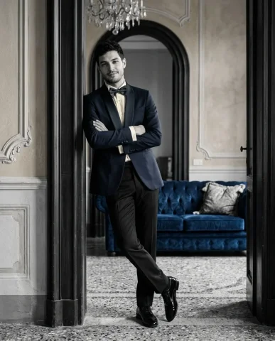 Tuxedo on Sapphire Velvet Sofa 4 — Nano Banana AI Prompt: Overhead editorial portrait shot from directly above. A handsome young man lying...