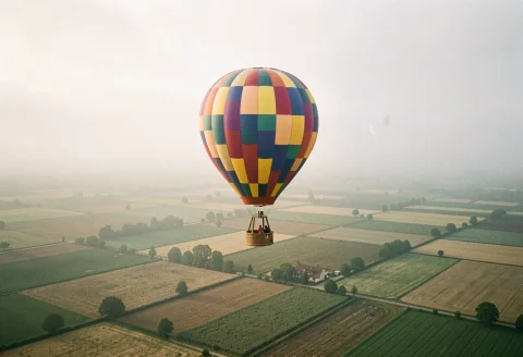 A Hot Air Balloon Drifting Over Patchwork Fields, Foggy Diff... — Stable Diffusion AI Prompt: a hot air balloon drifting over patchwork fields, foggy diffused light, shot on...