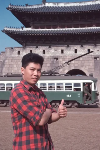 This Is A Color Photograph Capturing A Man Standing In Front... — Stable Diffusion AI Prompt: This is a color photograph capturing a man standing in front of a historic struc...