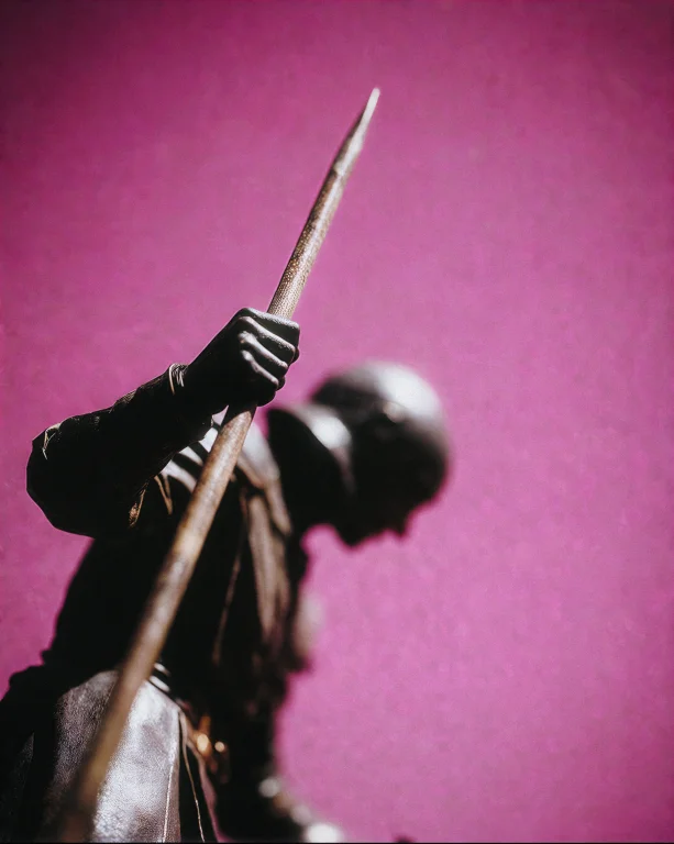 A Dark-silhouetted Figure Holds A Long Staff Angled Upward F...