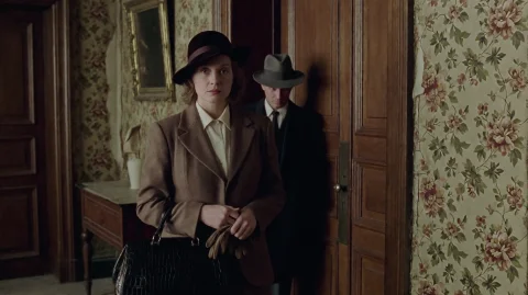 Pnst2002, A Woman In A Brown Hat And Matching Blazer Stands... — Stable Diffusion AI Prompt: pnst2002, A woman in a brown hat and matching blazer stands in a dimly lit hallw...