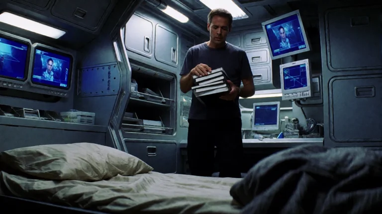 Slrs2002, A Man Stands In A Narrow, Utilitarian Room, Holdin...