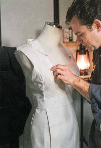 A Tailor Pinning Fabric On A Dress Form, Lantern Light, Grai... — Stable Diffusion AI Prompt: a tailor pinning fabric on a dress form, lantern light, grainy film texture, min...