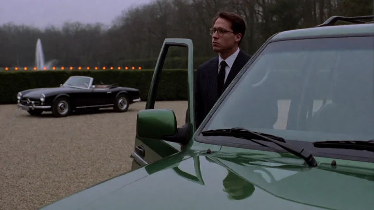 Nnthgt1999, A Man In A Dark Pinstripe Suit And Glasses Stand...