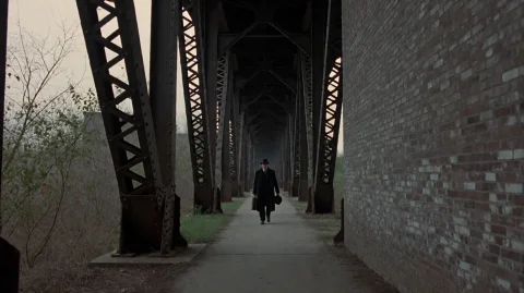 Rdtprdtn2002, A Solitary Figure In A Dark Coat And Hat Walks... — Stable Diffusion AI Prompt: rdtprdtn2002, A solitary figure in a dark coat and hat walks steadily down a nar...