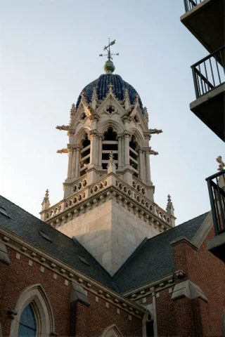 A Low-angle Shot Of A Tall, Ornate Stone Bell Tower Rising A... — Stable Diffusion AI Prompt: A low-angle shot of a tall, ornate stone bell tower rising above a brick church...