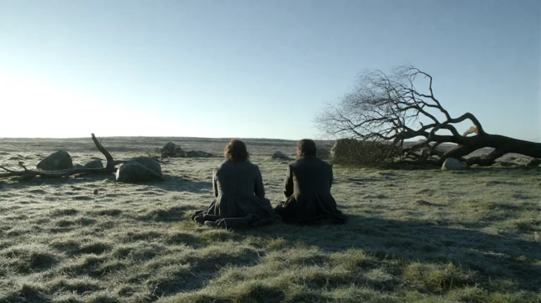 Gmthrnsssn1, Two Figures Sit On A Frost-dusted Grassy Field,...