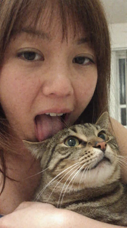 A Humorous Candid Indoor Selfie Of A Young East Asian Woman...