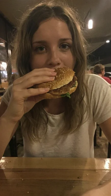 Foto De Una Mujer Comiendo Una Hamburguesa En Pleno Restaura...