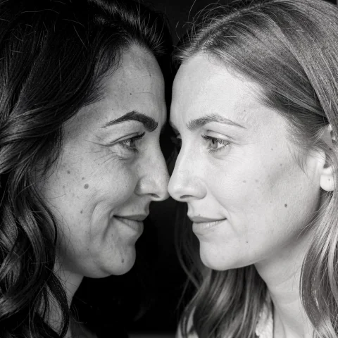 Close Up Black And White Photo Of A Woman And A Woman, Their... — FLUX AI Prompt: Close up black and white photo of a woman and a woman, their foreheads touching,...