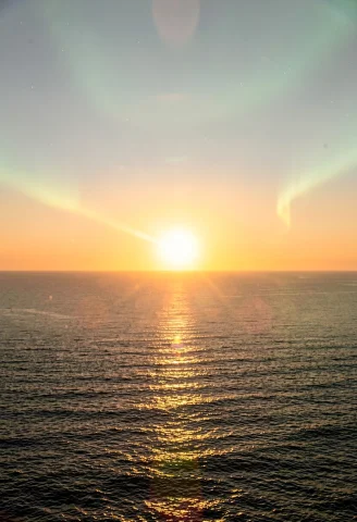 The Sun Rising Over A Calm And Empty Ocean, Documentary Phot... — Stable Diffusion AI Prompt: the sun rising over a calm and empty ocean, documentary photography, aurora glow...