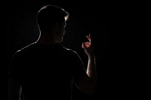 Photograph Of A Silhouetted Male Figure Against A Completely... — Stable Diffusion AI Prompt: Photograph of a silhouetted male figure against a completely black background. T...