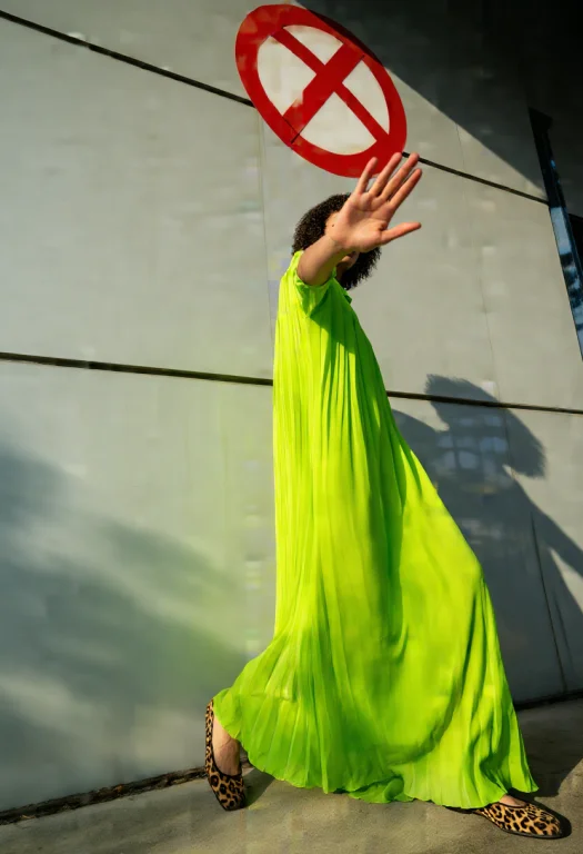 Woman In Neon Green Pleated Maxi Dress, Short Curly Hair, Le...