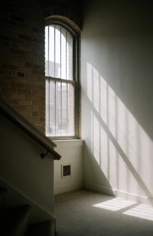 An Interior Space With Sunlight Streaming Through A Tall Arc... — Stable Diffusion AI Prompt: an interior space with sunlight streaming through a tall arched window casting s...